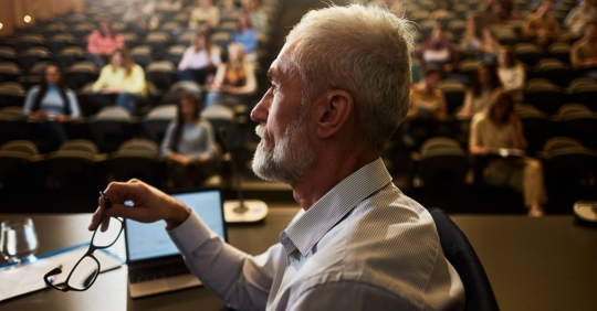 Professor looking at something in the distance while in front of his college class